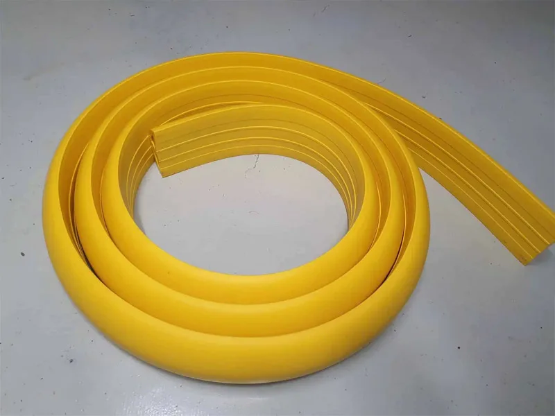 Yellow rubber floor bunding showing its profile and fixing channels