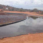 Heavy duty XR5 containment boom separating oil and grease in waste transfer pond at Port Augusta facility.