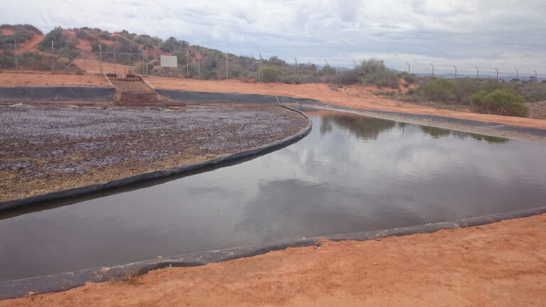 Heavy duty XR5 containment boom separating oil and grease in waste transfer pond at Port Augusta facility.