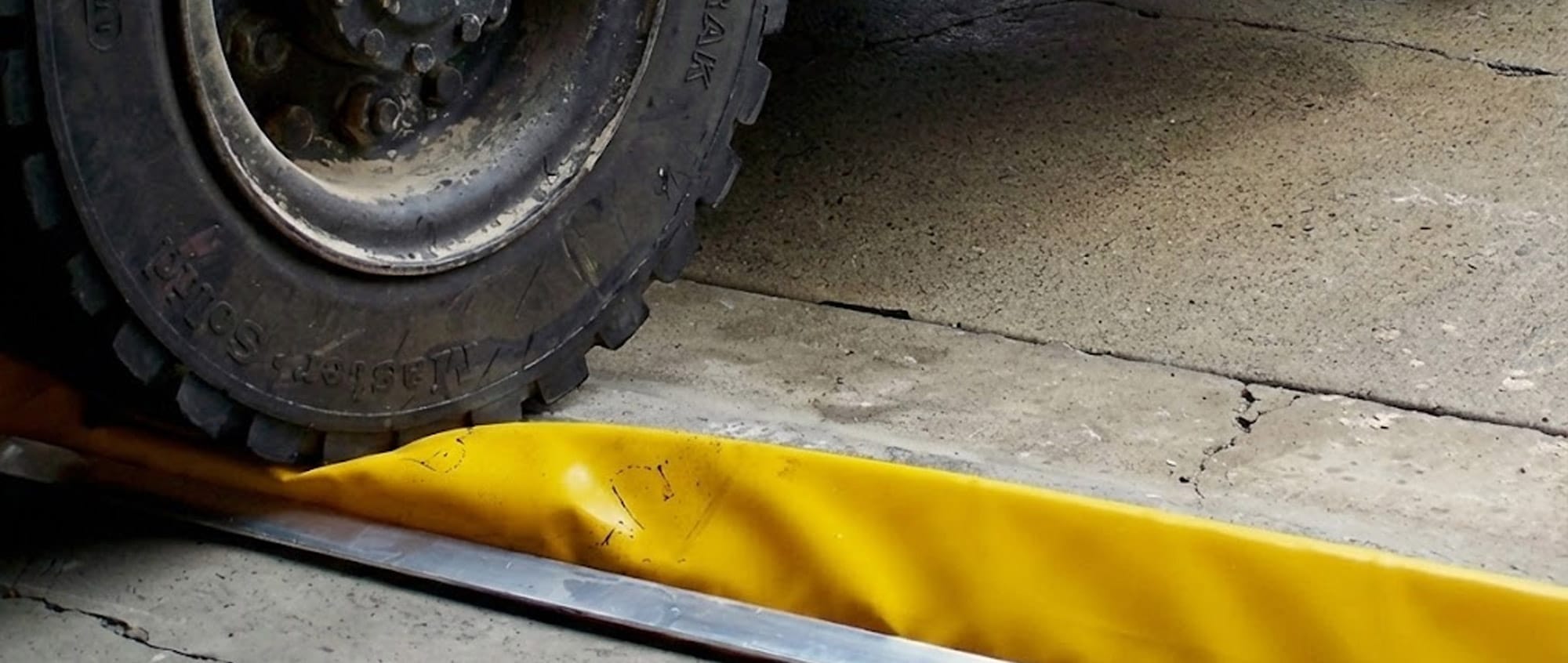 Vehicle wheel crossing flexible floor bunding at low speed