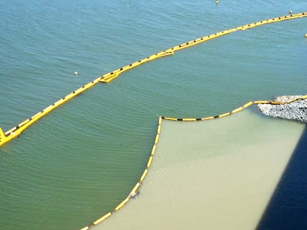 Floating silt curtain containing sediment during marine construction works