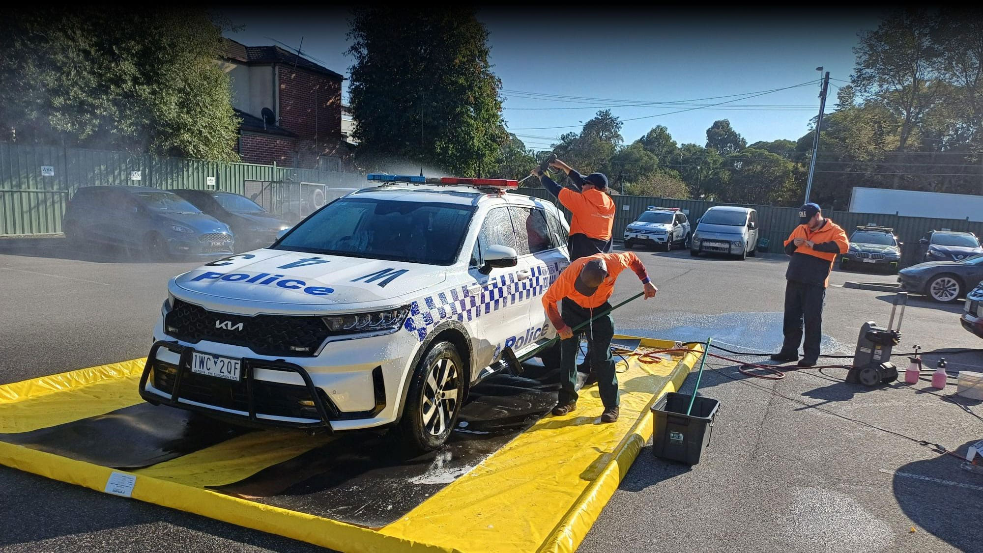 Police vehicle washdown using portable vehicle wash mat containment system