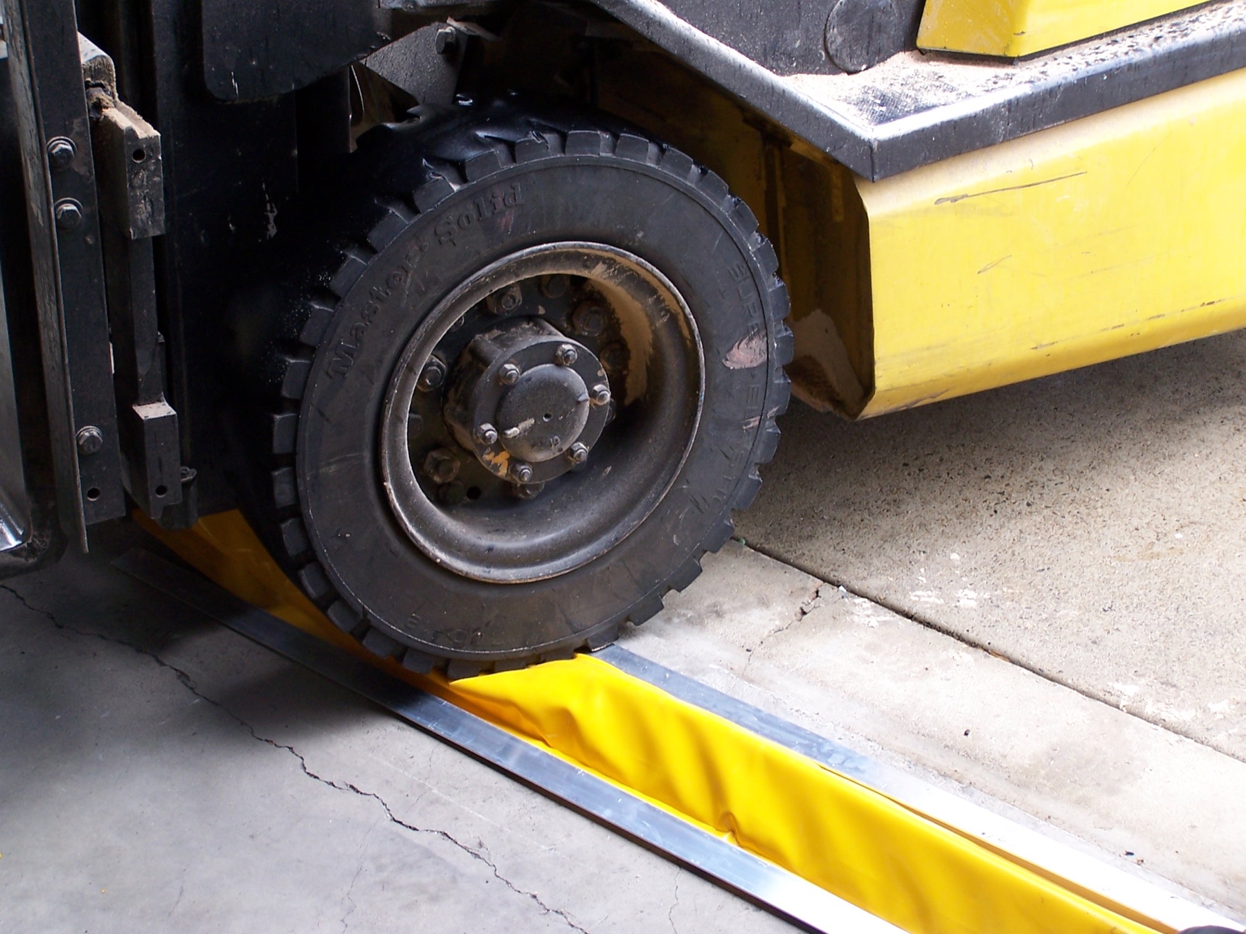Forklift crossing a yellow flexible floor bund at low speed